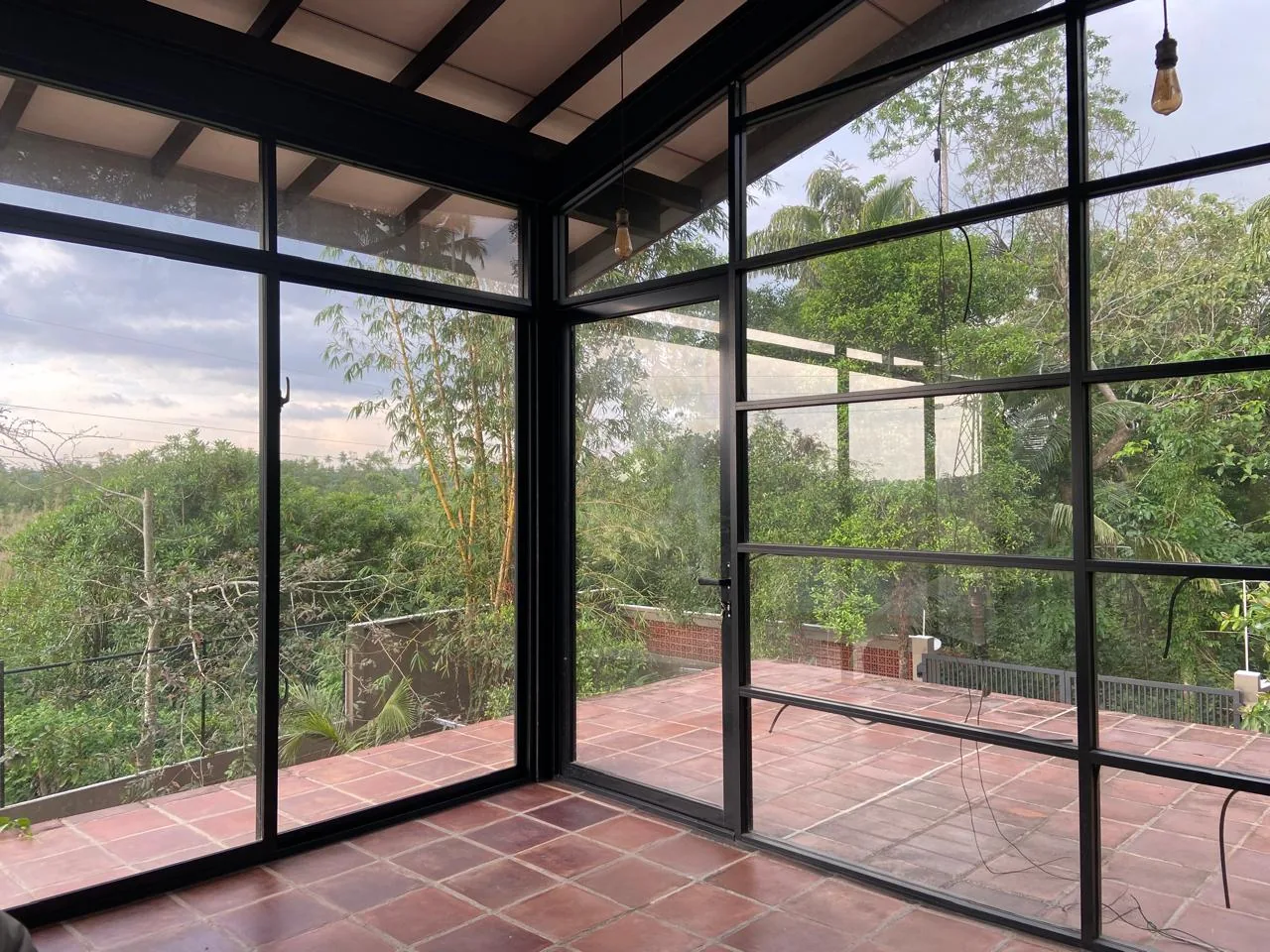Glass lounge looking out to tropical greenery at Goraka Villa